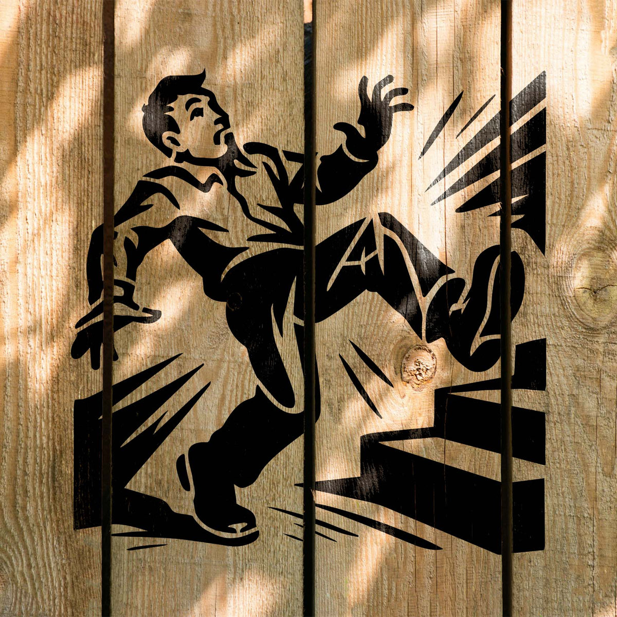Across wooden boards, the Slip Hazard Stencil depicts a man slipping backward beside raised steps.