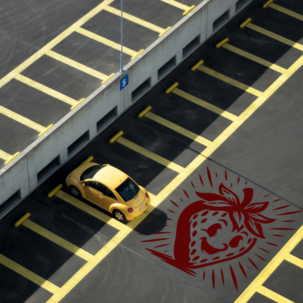 Red Smiling Cartoon Strawberry Stencil painted on a parking lot beside a yellow car.