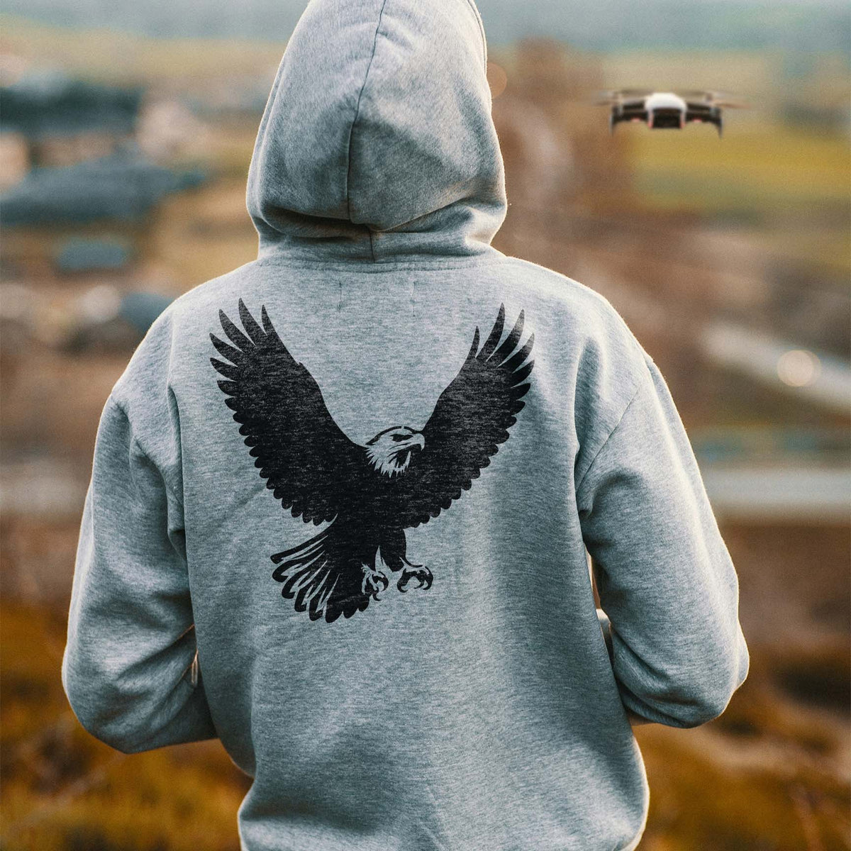 A gray hoodie's back features the Soaring Bald Eagle Stencil with sweeping wings and outstretched talons.