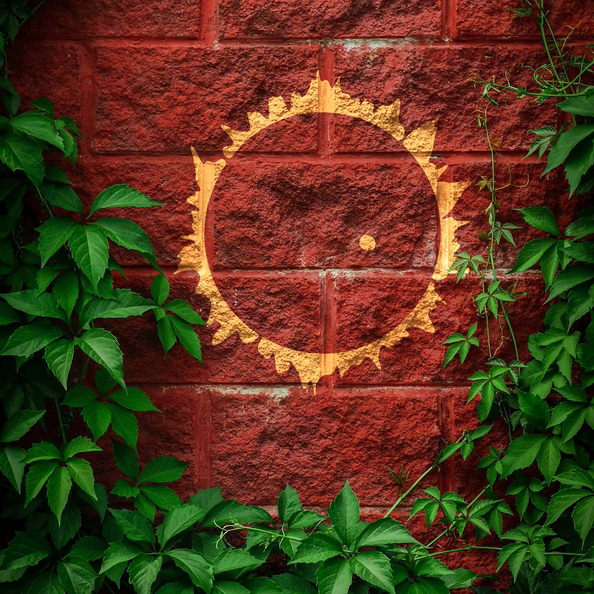 Golden corona glows against red brick in the Solar Eclipse Corona Stencil framed by green ivy