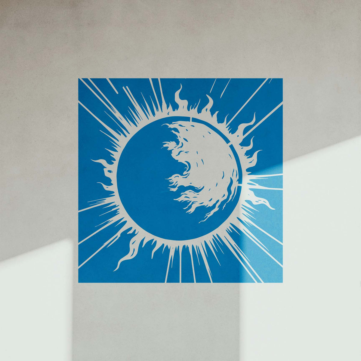 Sunlit blue Solar Flare Eclipse Stencil reveals sweeping flames and rays on a white wall