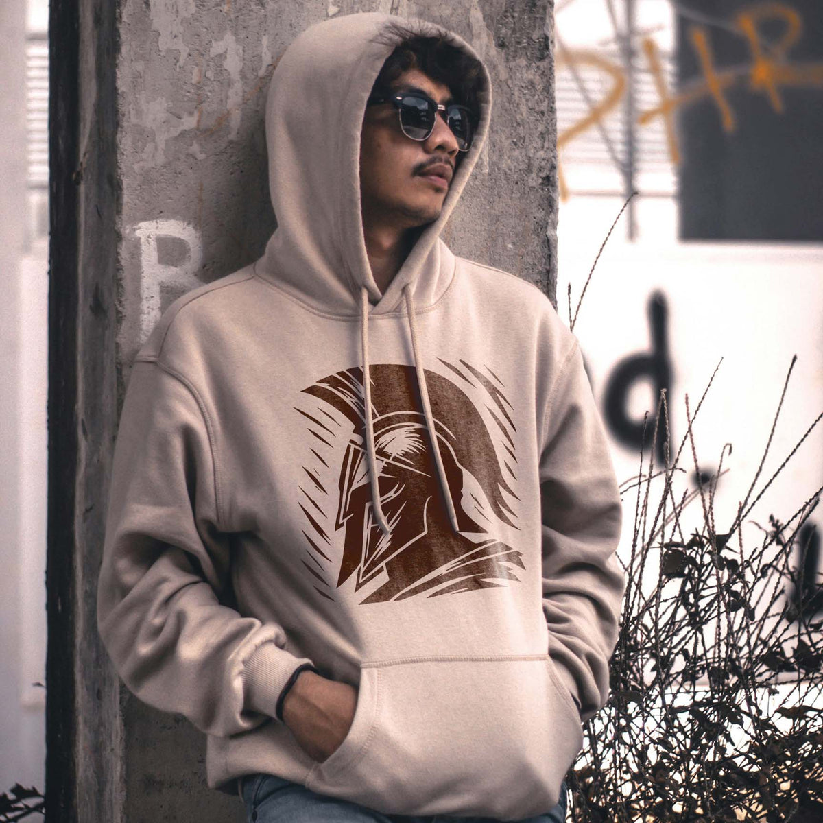 Ancient Spartan Warrior Helmet Stencil printed brown on the front of a beige hoodie.