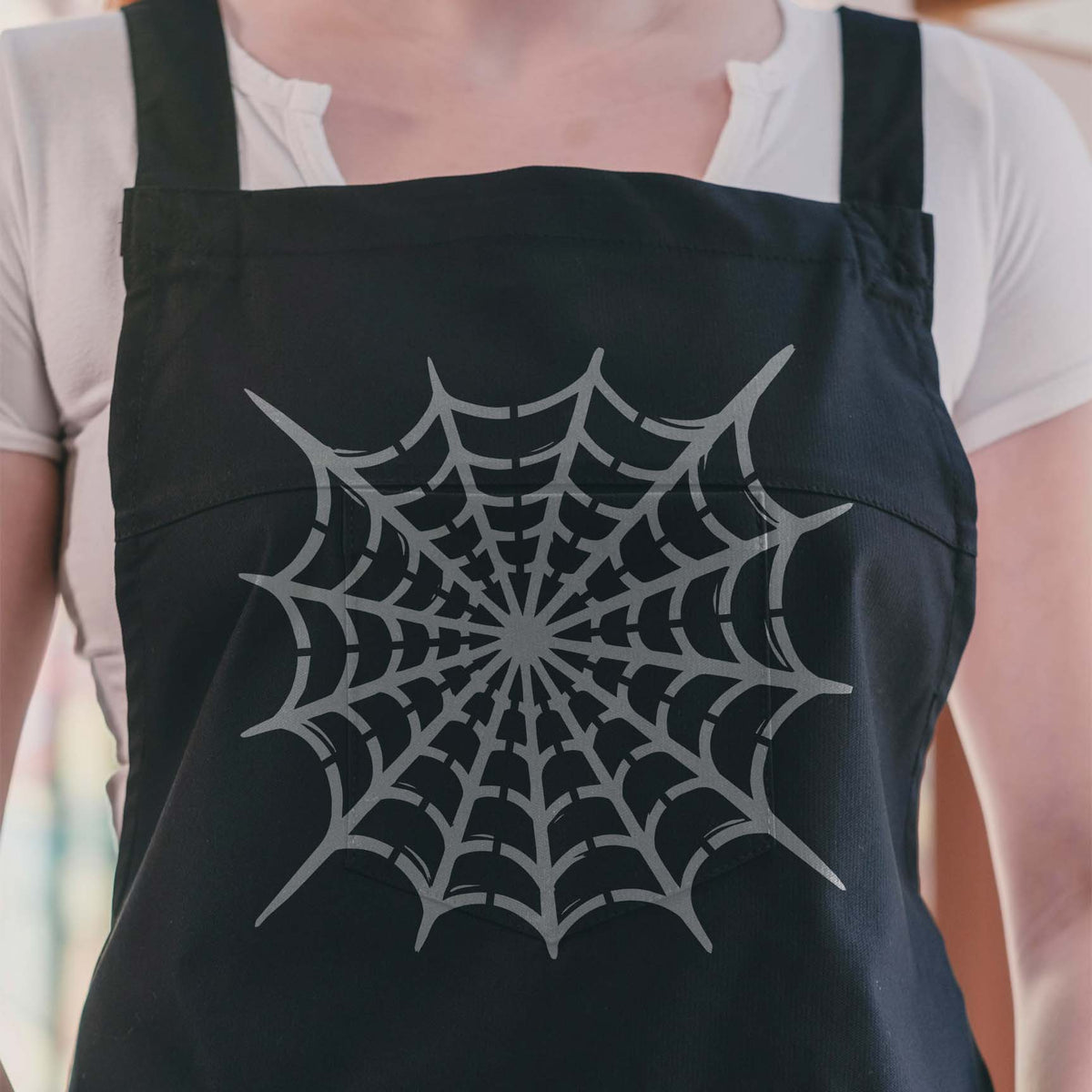 Silver Radial Spider Web Stencil spreads across a black apron in a crisp centered design