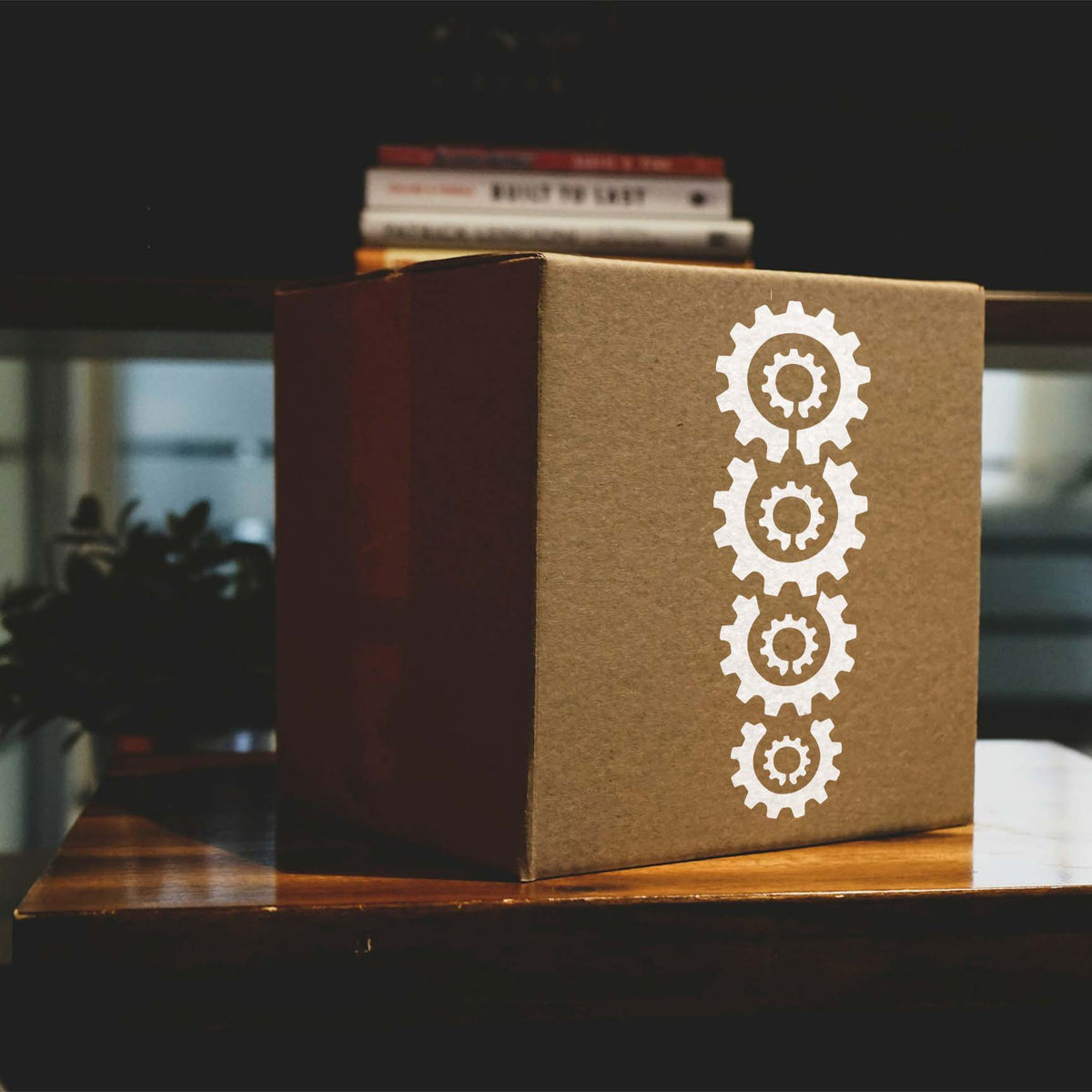 Stacked Gears Stencil printed in white on a kraft box, showing four vertically aligned cog shapes.