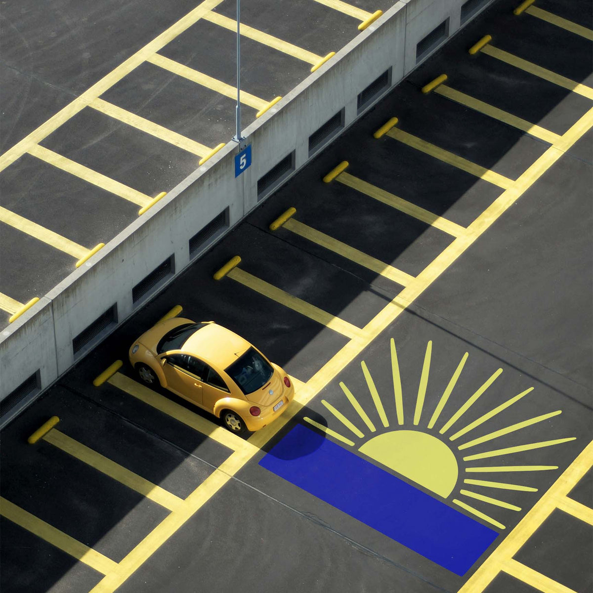 Parking lot features Radiant Sunrise Horizon Stencil with yellow rays rising above a blue horizon