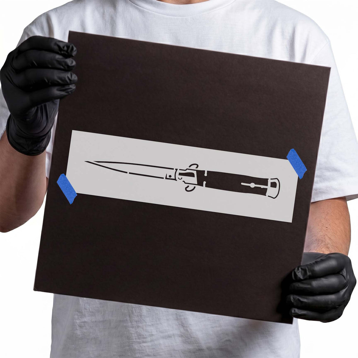Switchblade stencil featuring an extended pointed blade, pivot mechanism, and detailed dark handle
