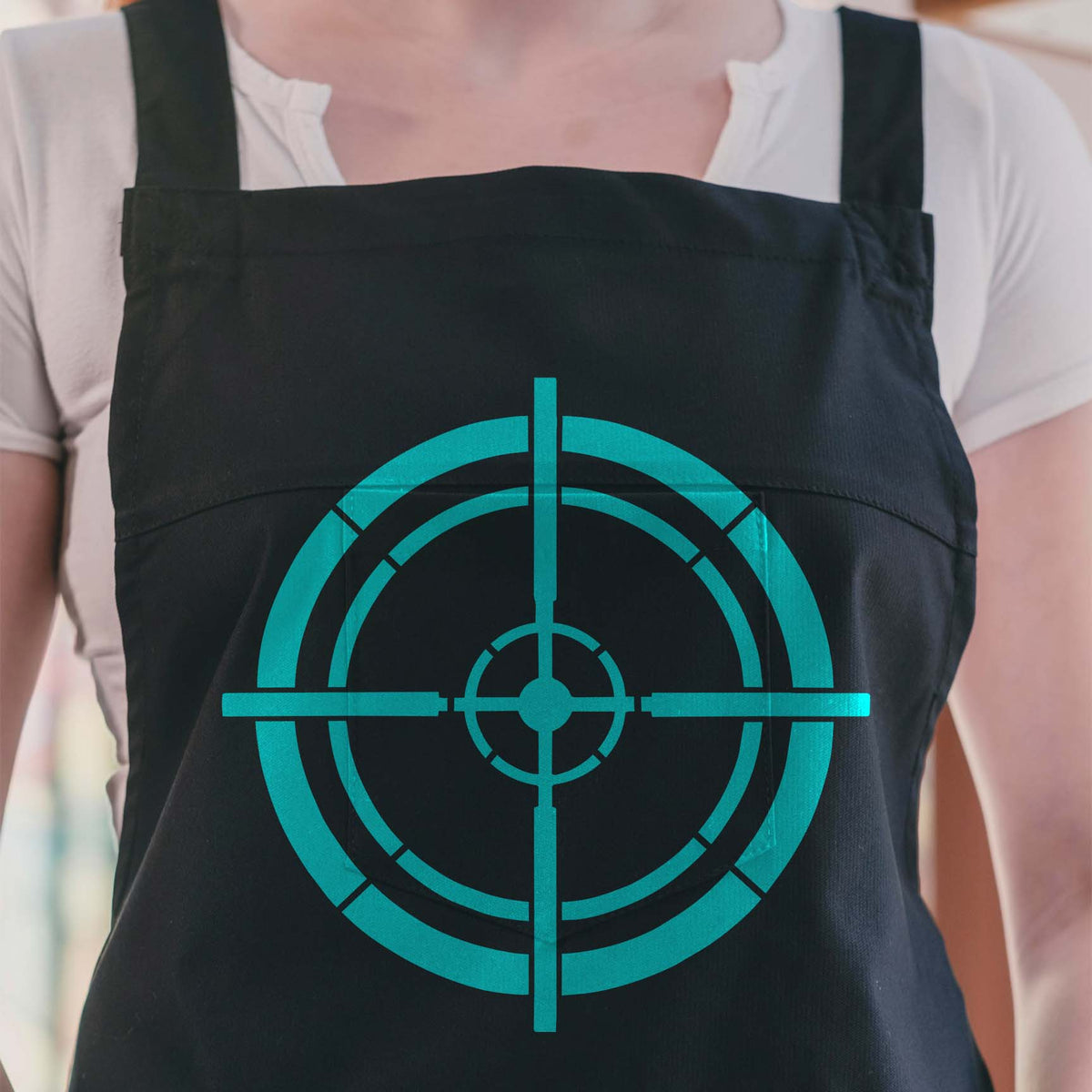 Turquoise Tactical Crosshair Reticle Stencil stands out sharply on a black apron