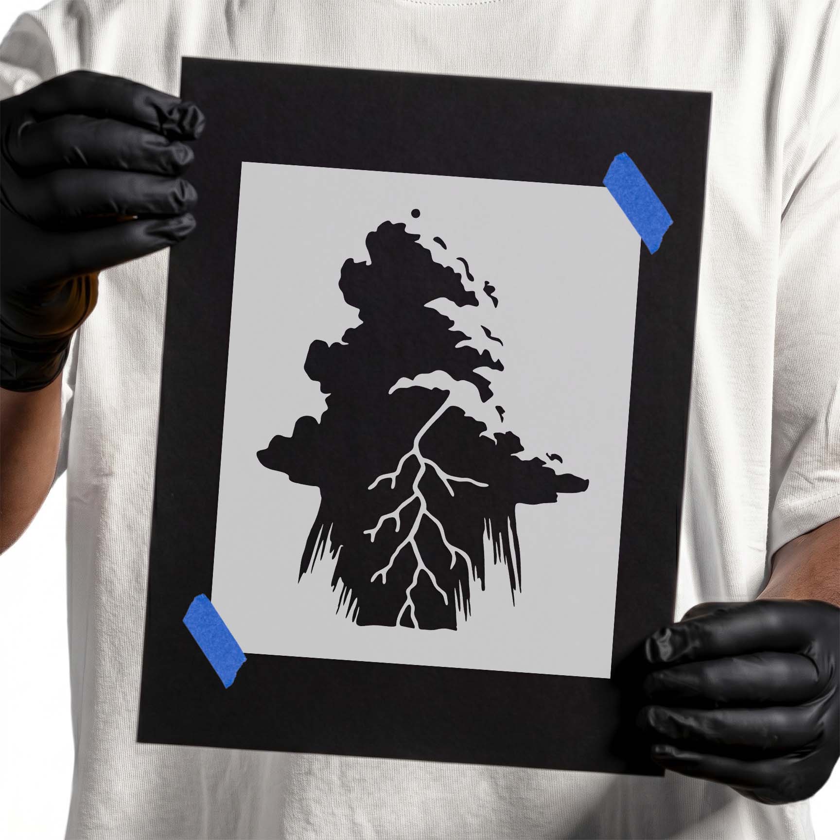 Person holding Lightning Storm Cloud Stencil taped to cardboard