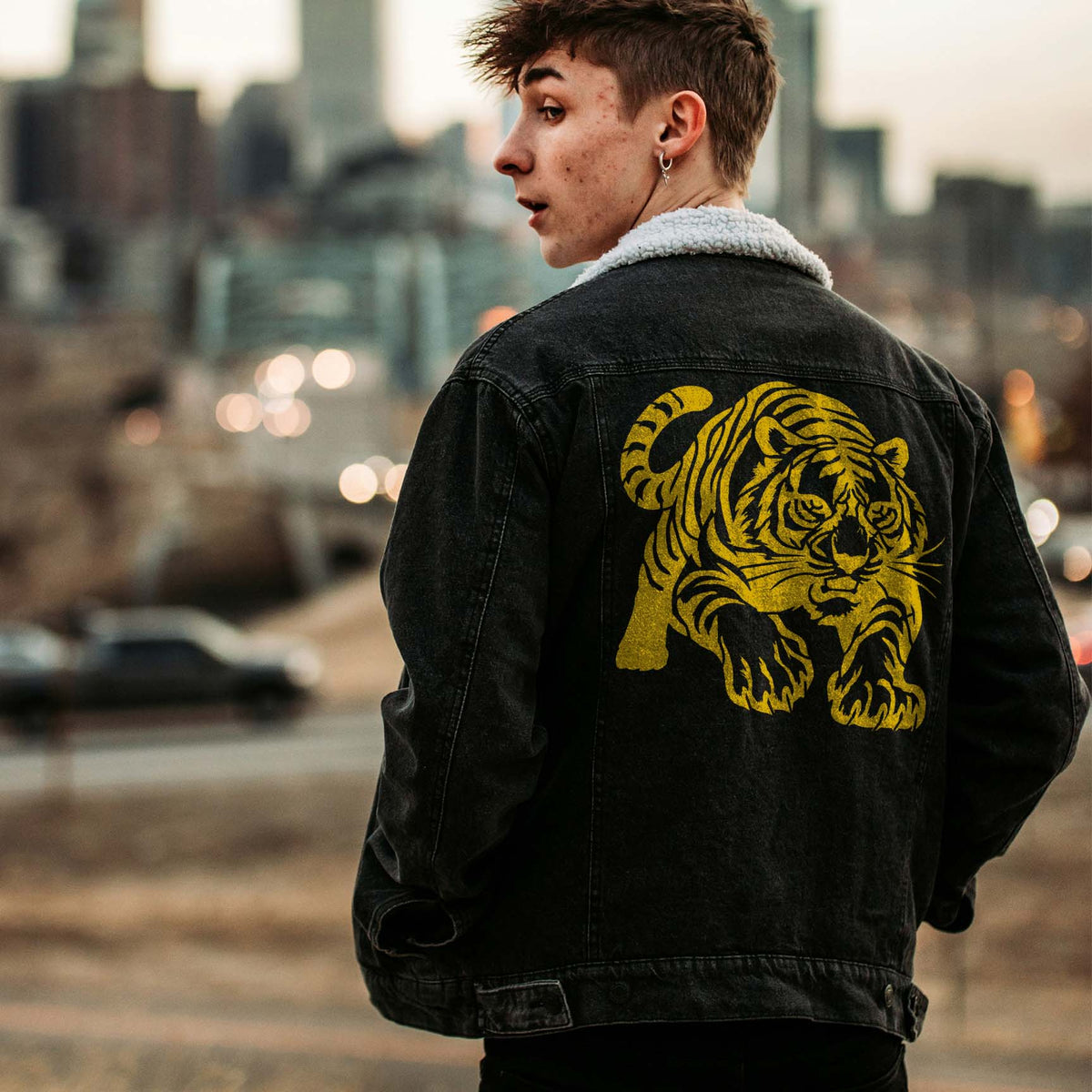 Golden Tiger on the Prowl Stencil lunges across the back of a black denim jacket