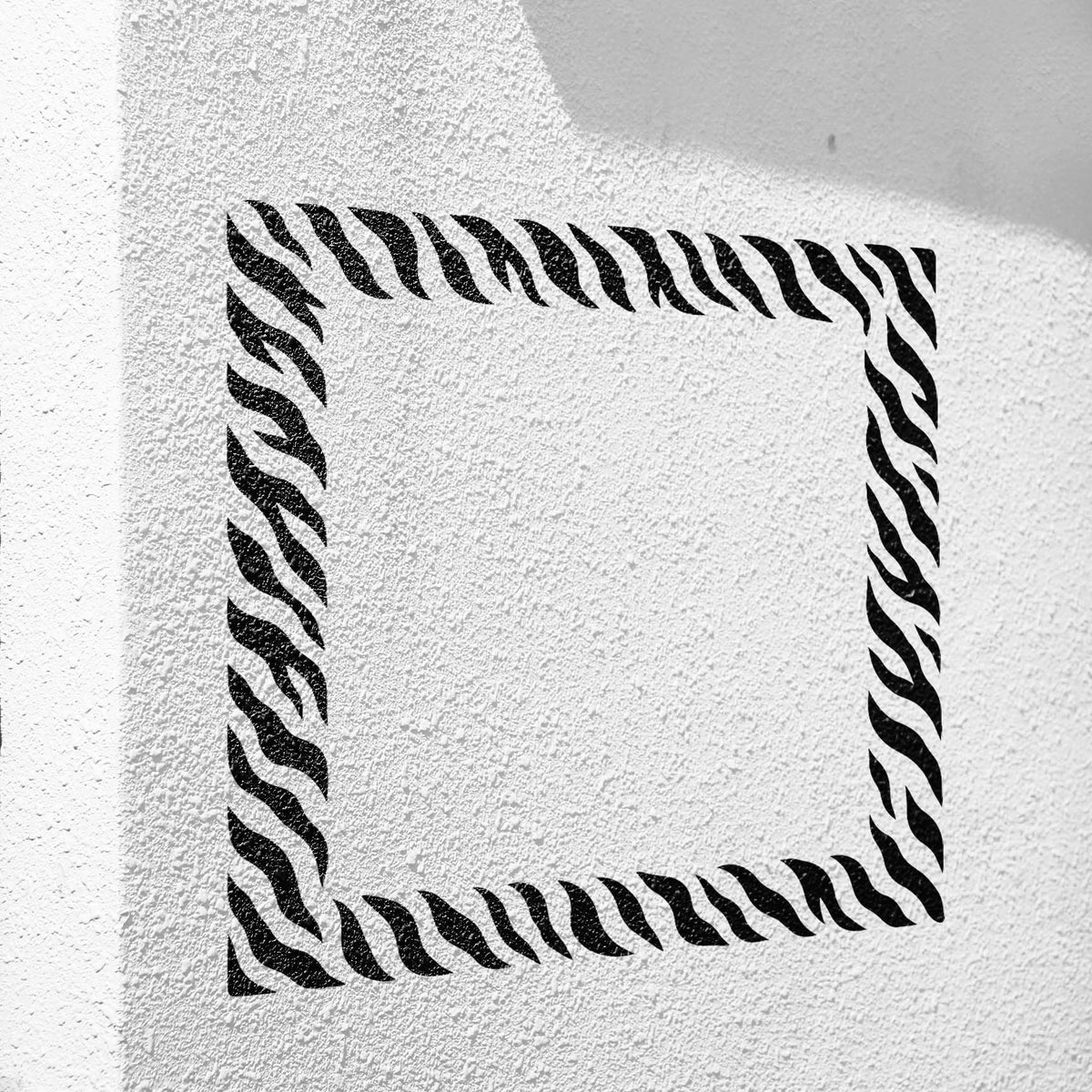 Sleek Tiger Stripe Border Stencil outlines an open square on a textured white wall