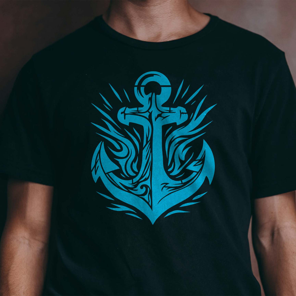 Blue Tribal Anchor Emblem Stencil creates a bold nautical graphic across a black T-shirt