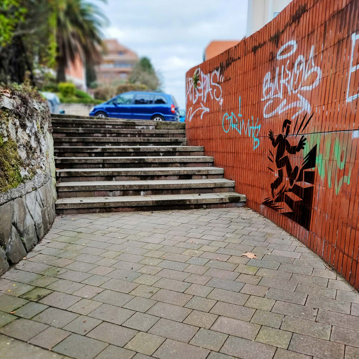 Beside outdoor stairs, the Trip Hazard Warning Stencil shows a figure tripping over raised steps.