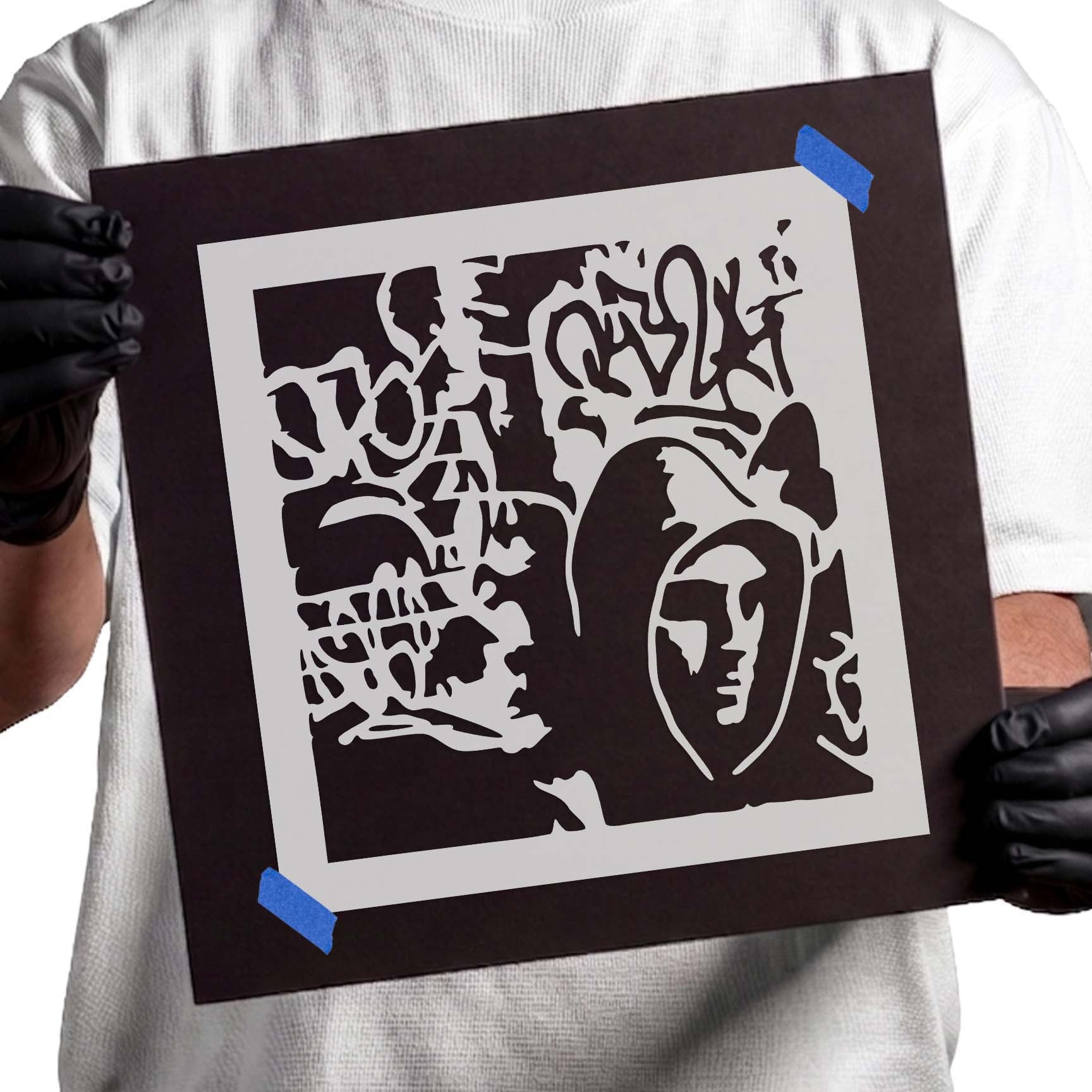 Person holding Urban Street Graffiti Stencil taped to black cardboard