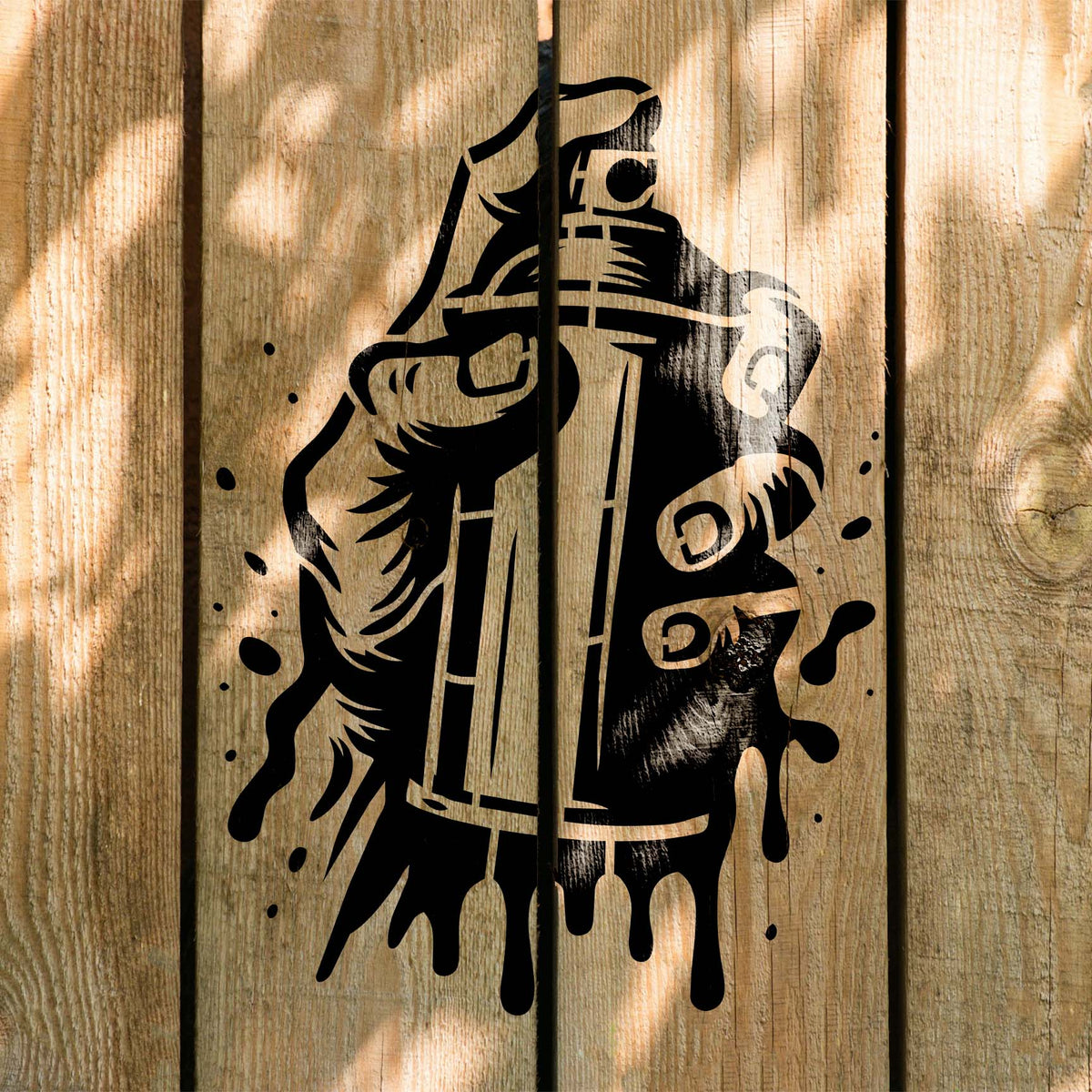 Sunlit wood fence displays the Urban Spray Paint Can Stencil with bold black graffiti detail.