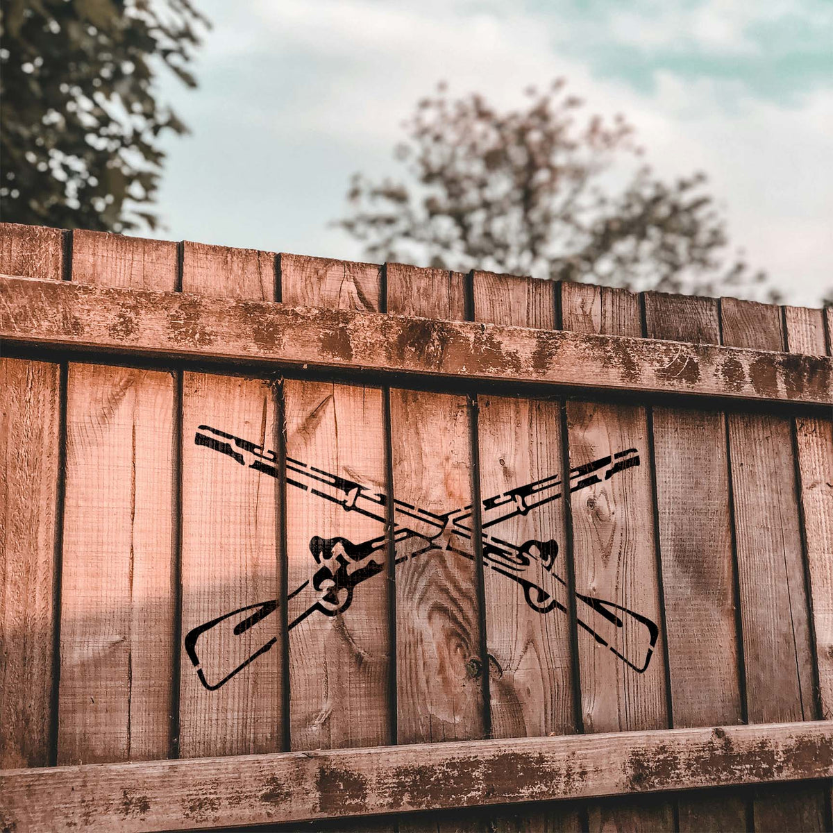 Vintage Crossed Rifle stencil makes a bold heritage-style emblem on wooden fence