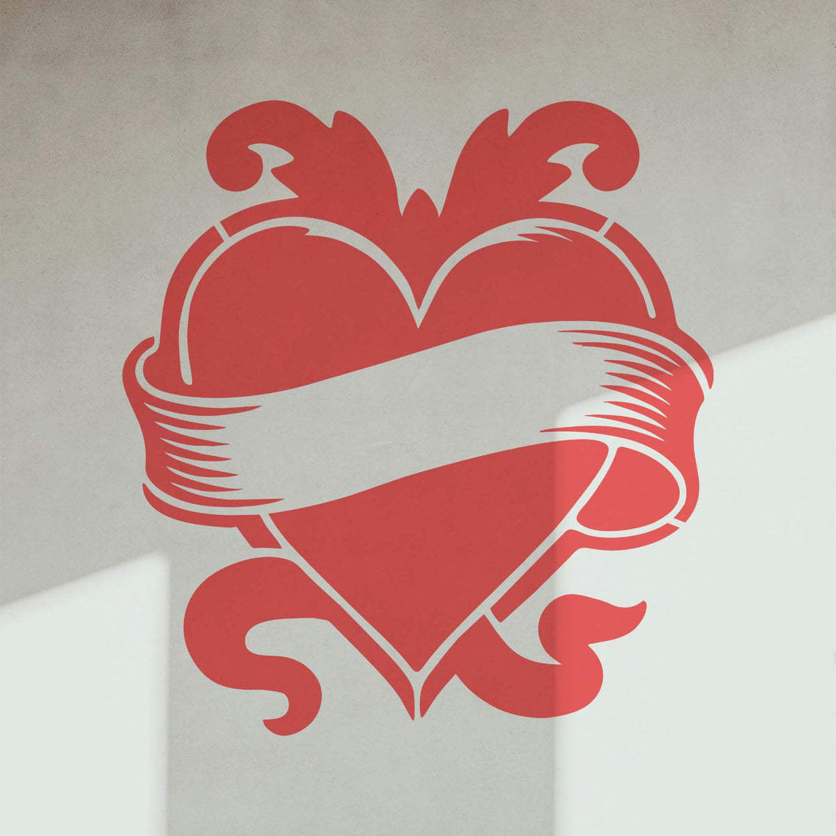 Sunlit wall displays the Vintage Heart Banner Stencil with a red heart and sweeping blank ribbon