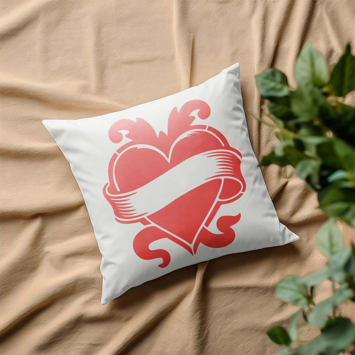Vintage Heart Banner Stencil decorates a white pillow with a bold red heart and flowing ribbon