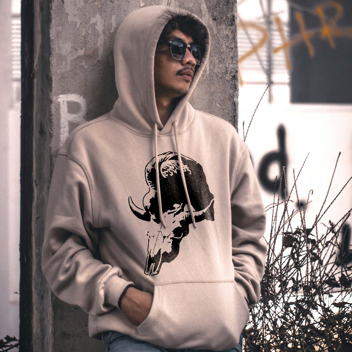Bold Vulture Skull Silhouette Stencil appears in black on a beige hoodie worn outdoors