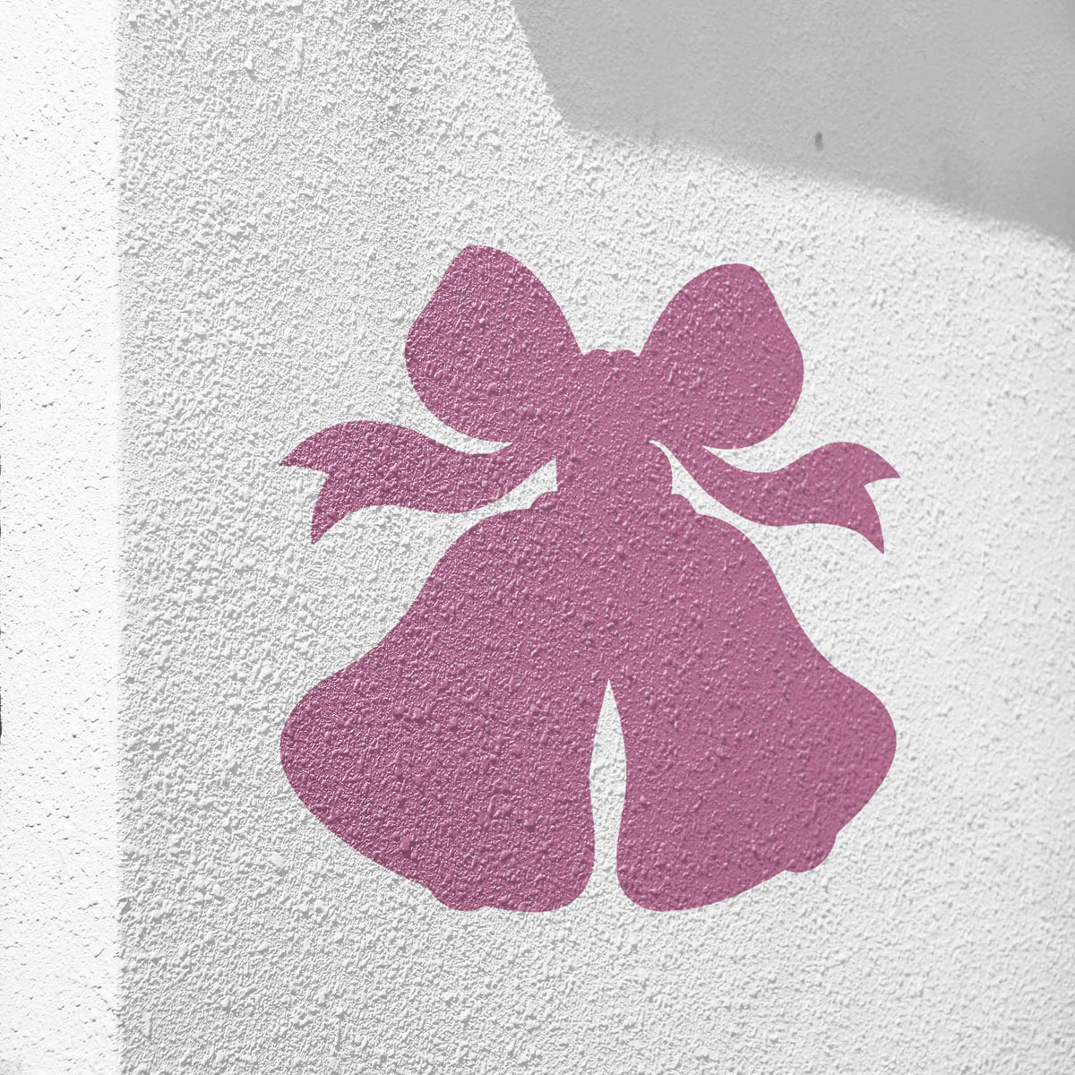 Wedding Bells stencil with ribbon bow painted on textured white wall