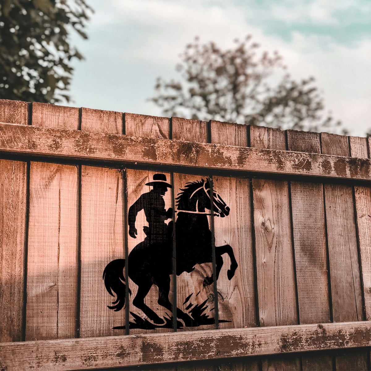 Western Cowboy on Rearing Horse Stencil is displayed in black across a weathered wooden fence.