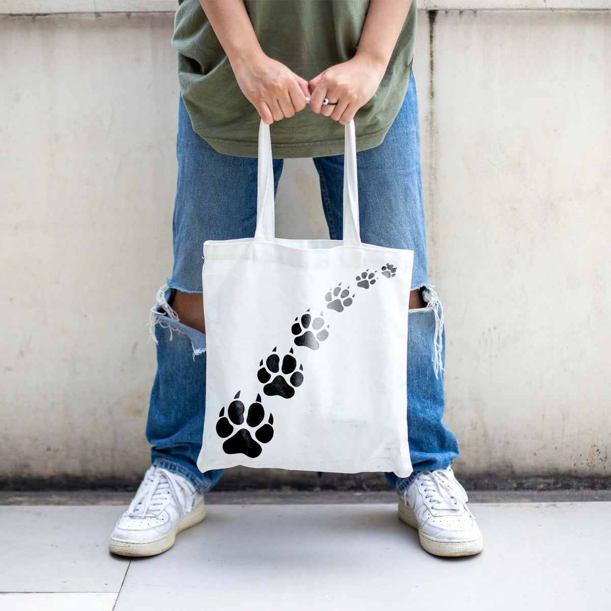 Wild Animal Paw Print Trail Stencil tracks wander diagonally across a white canvas tote bag