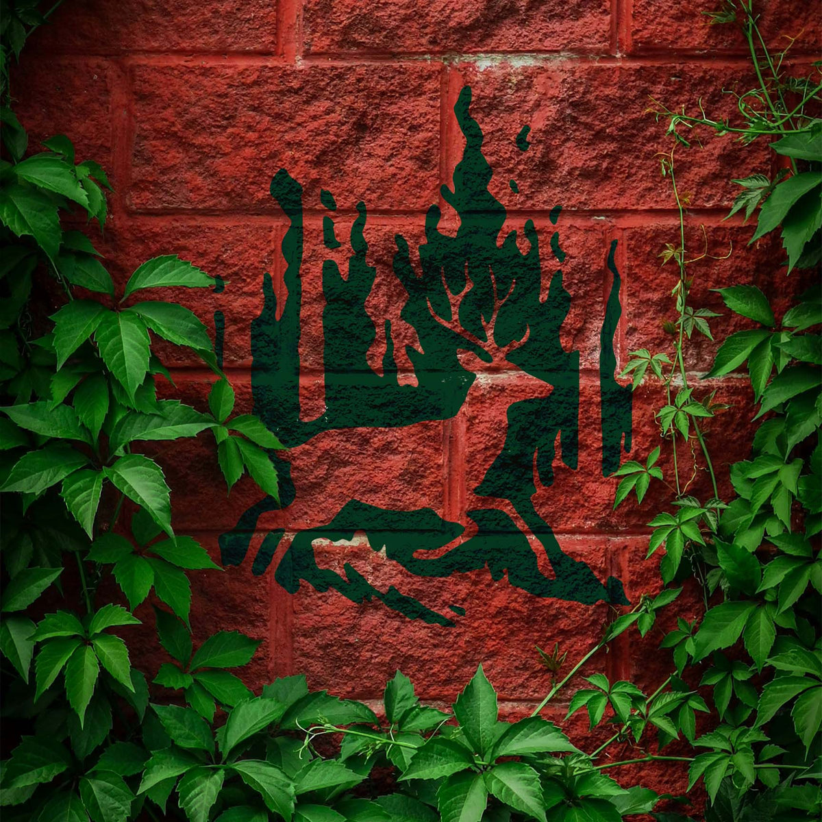 Wildfire buck stencil painted dark green on a red brick wall