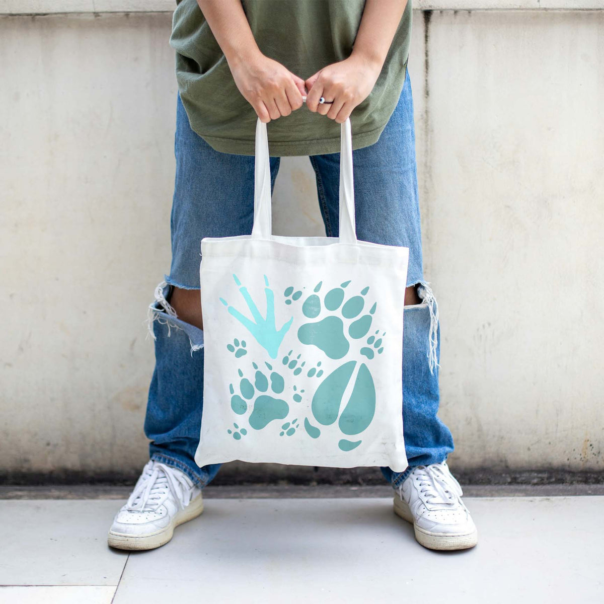 Playful wildlife animal tracks stencil decorating a white canvas tote bag