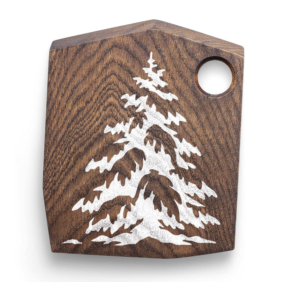 Winter evergreen pine stencil with snow-covered branches on a wooden cutting board