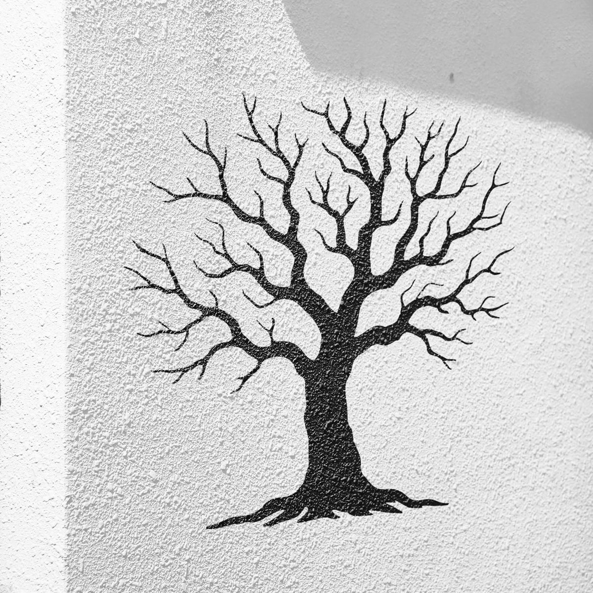 Winter tree stencil with bare branches painted on a textured white wall