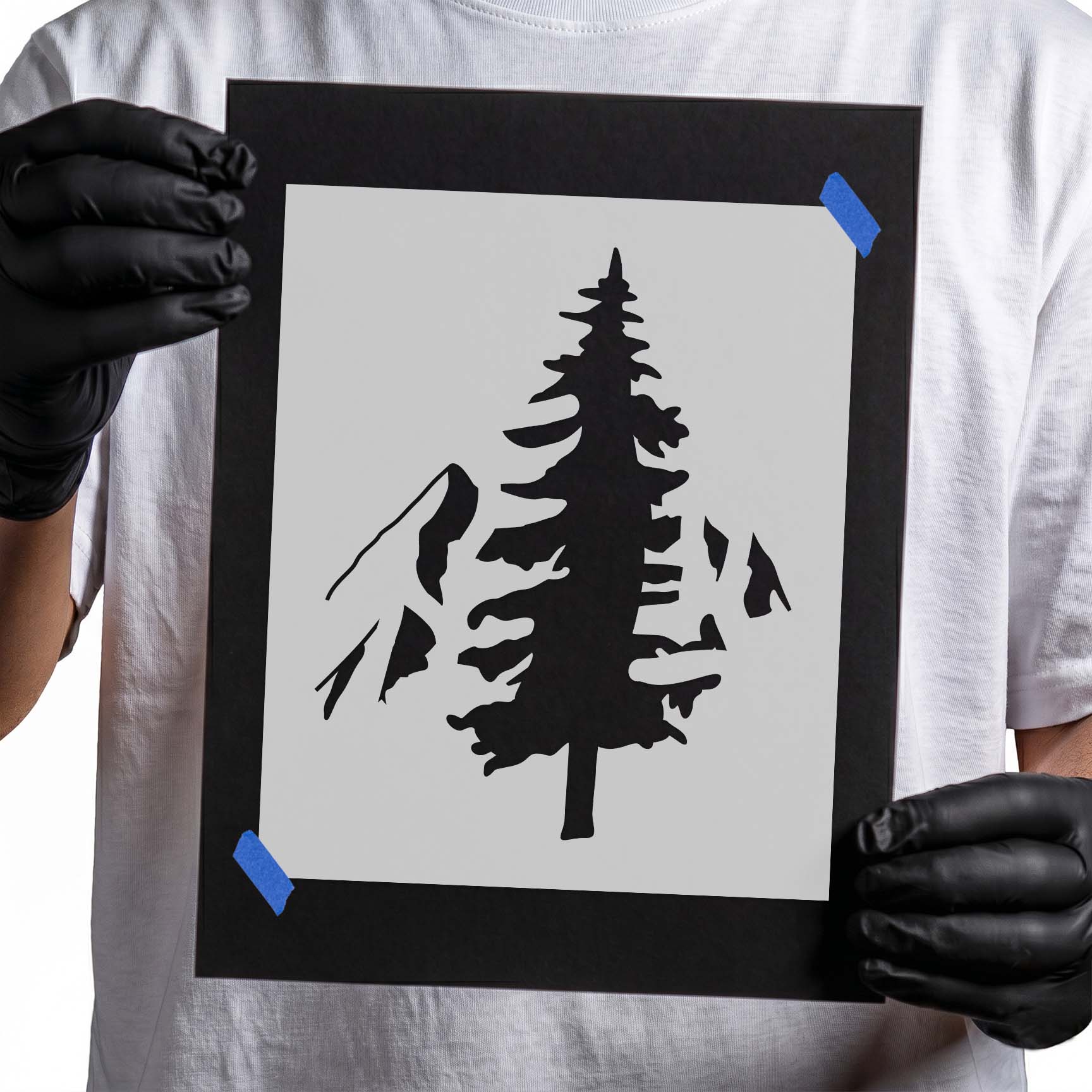 Evergreen tree stencil framed by rugged mountain peaks