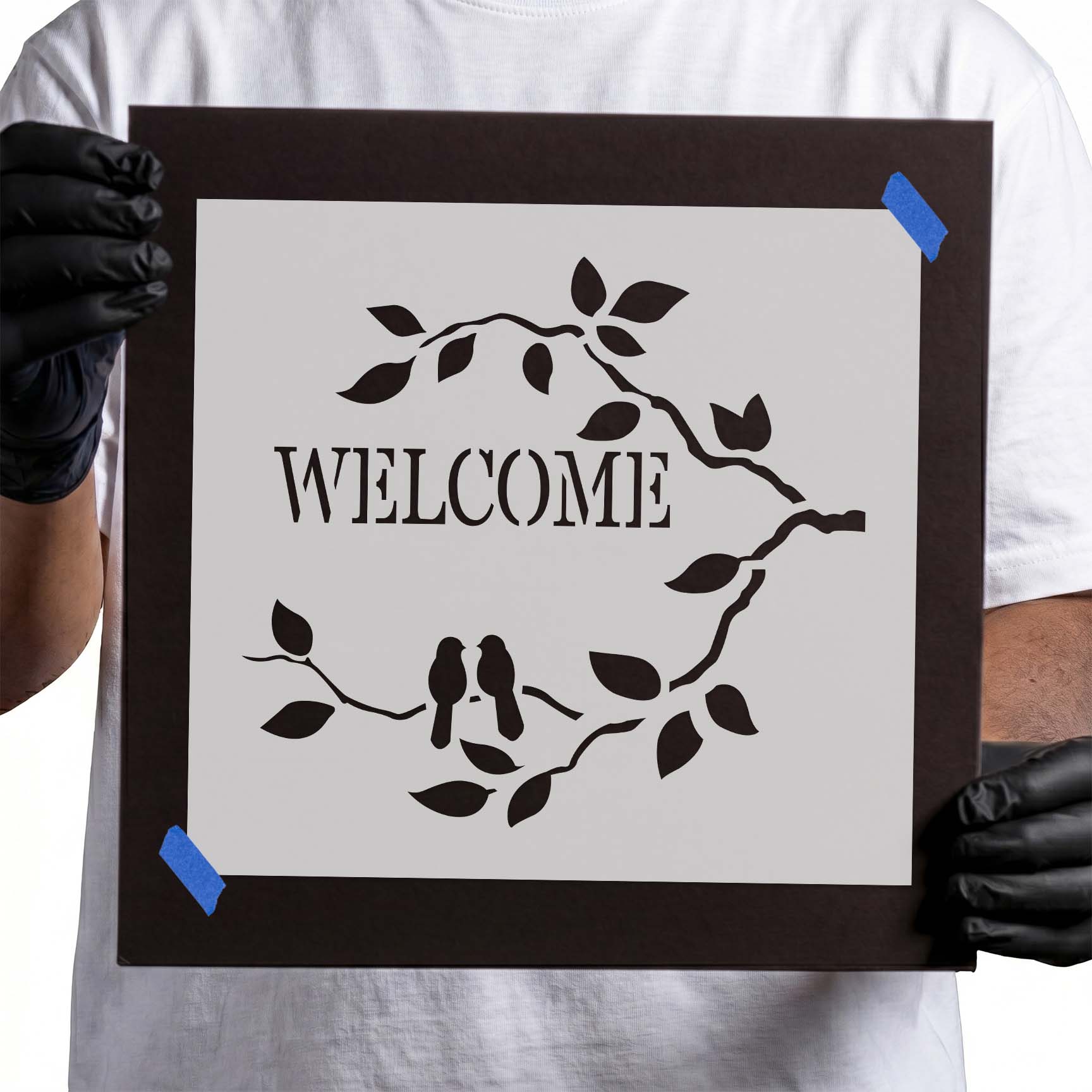 Welcome stencil framed by leafy branches with two perched birds