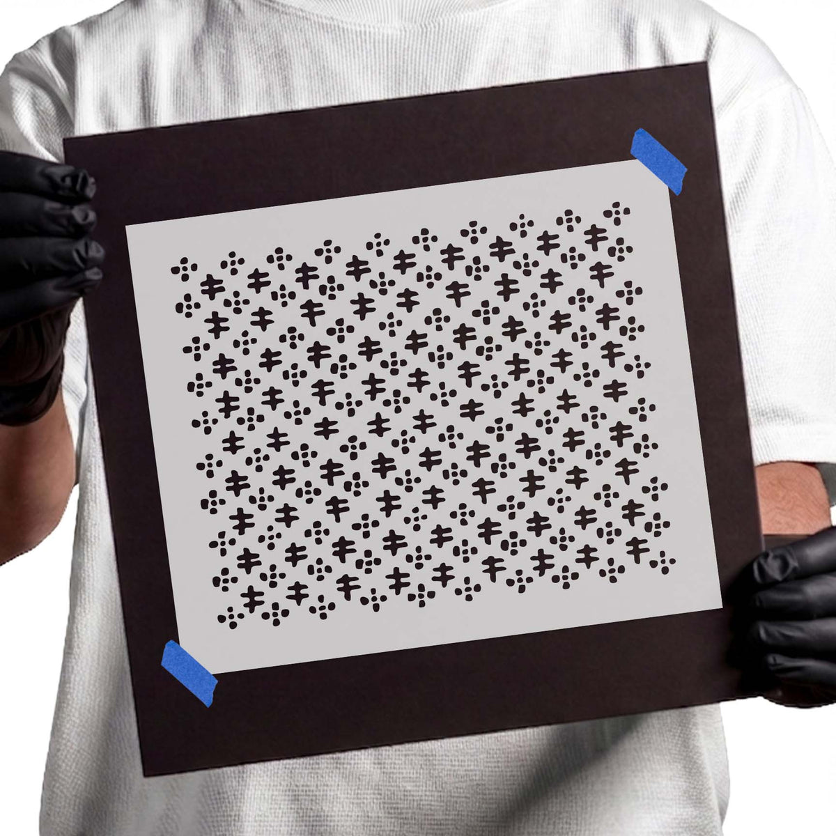Abstract stencil with repeating cross-like symbols and dotted clusters