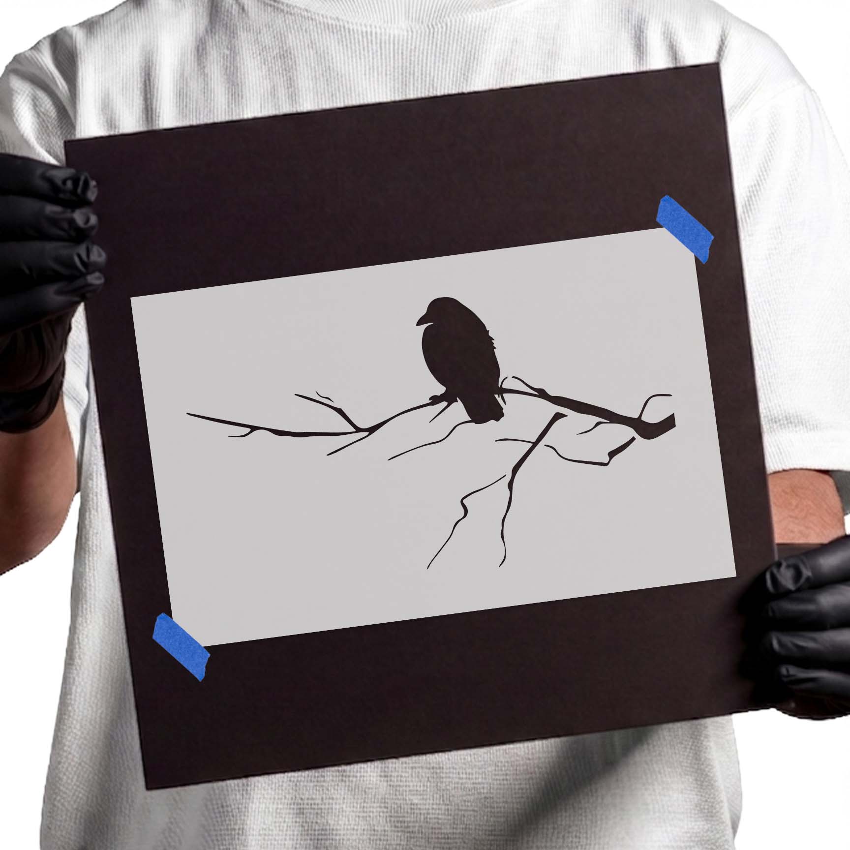 Crow stencil perched on a slender bare tree branch