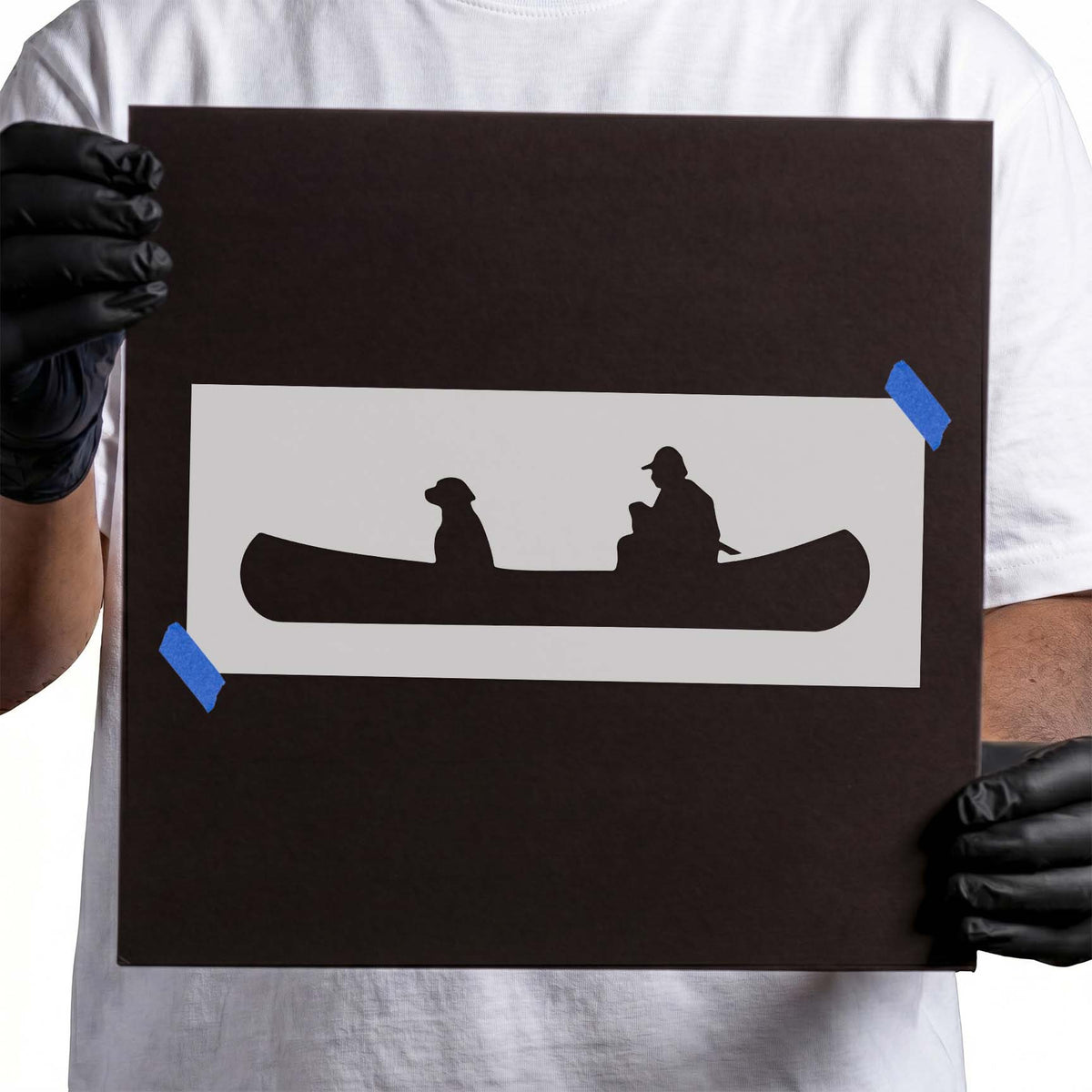 Man and dog stencil seated together in a long canoe silhouette