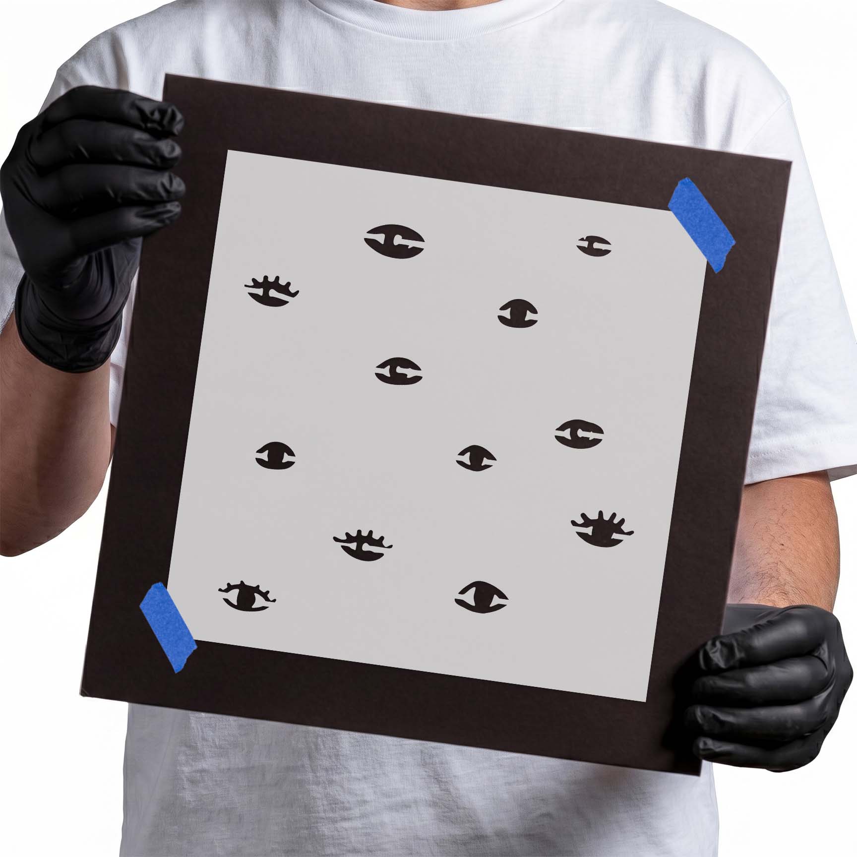 Person holding reusable spooky eyes pattern stencil for Halloween crafts.