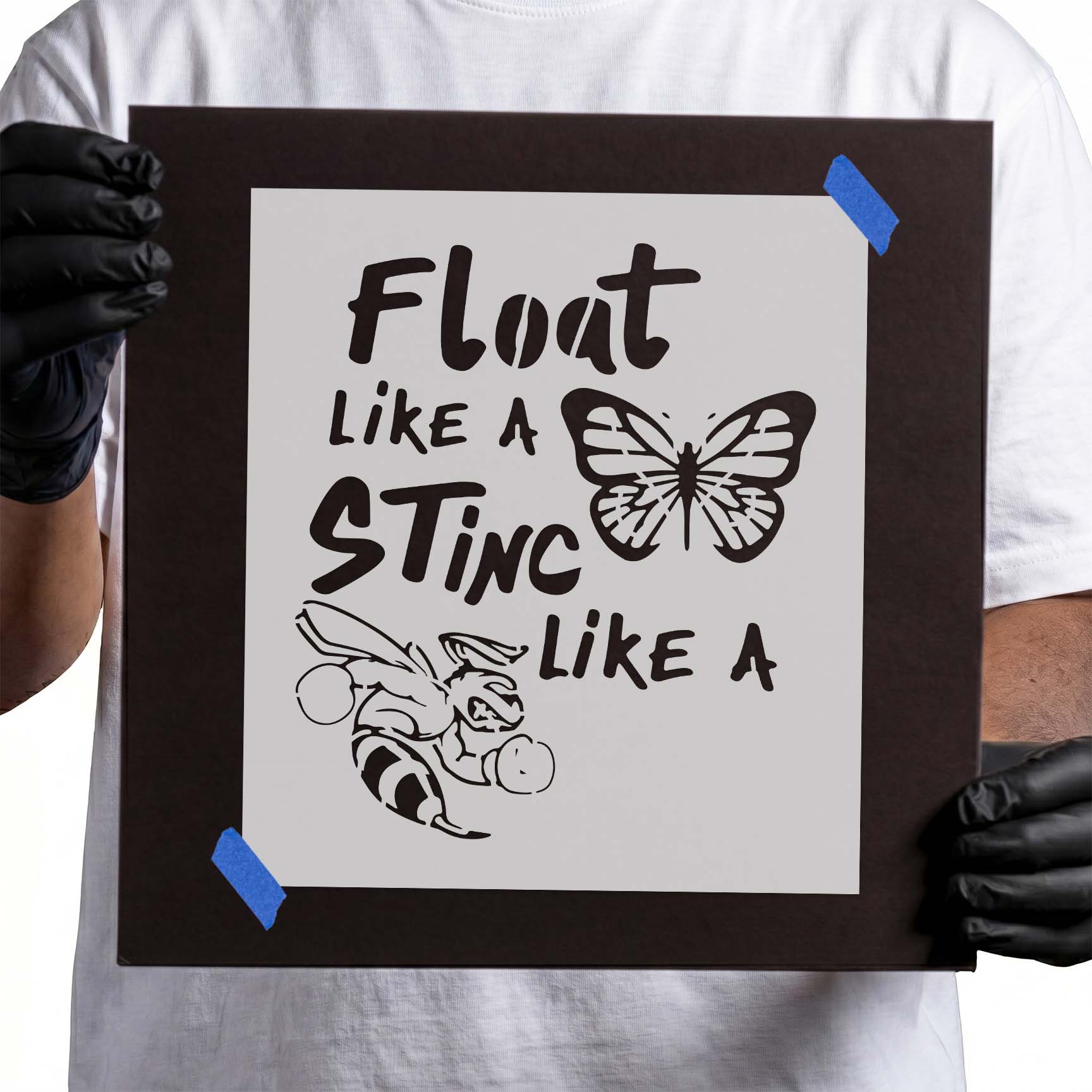 Person holding reusable “Float Like a Butterfly, Sting Like a Bee” stencil.