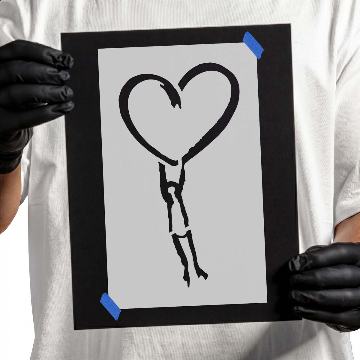 Heart stencil with small figure hanging from the outlined shape