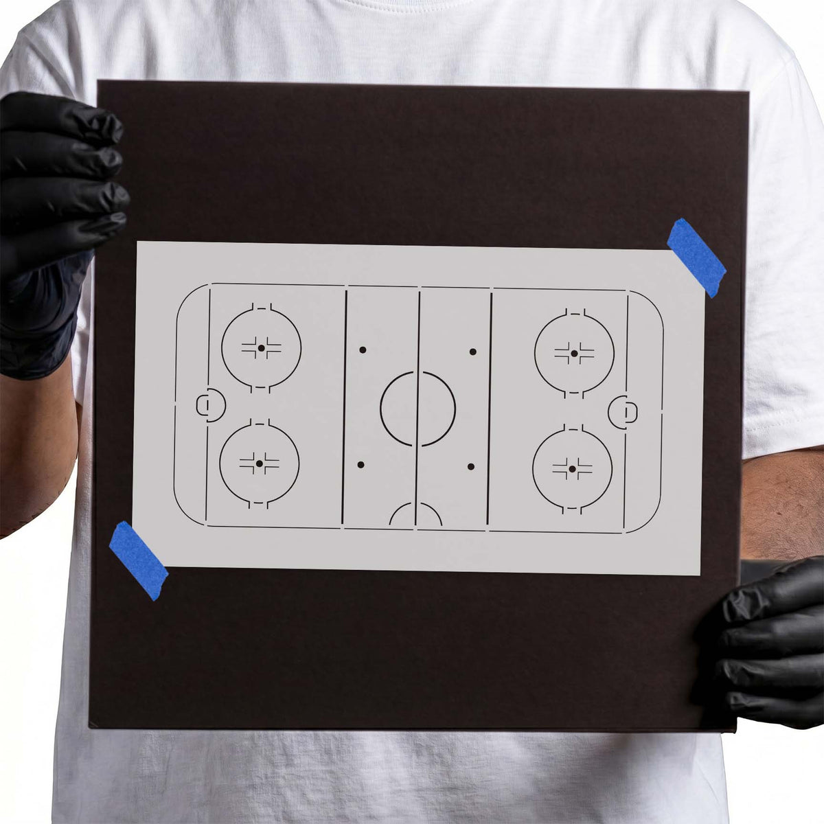 Gloved hands holding reusable Hockey Rink Stencil