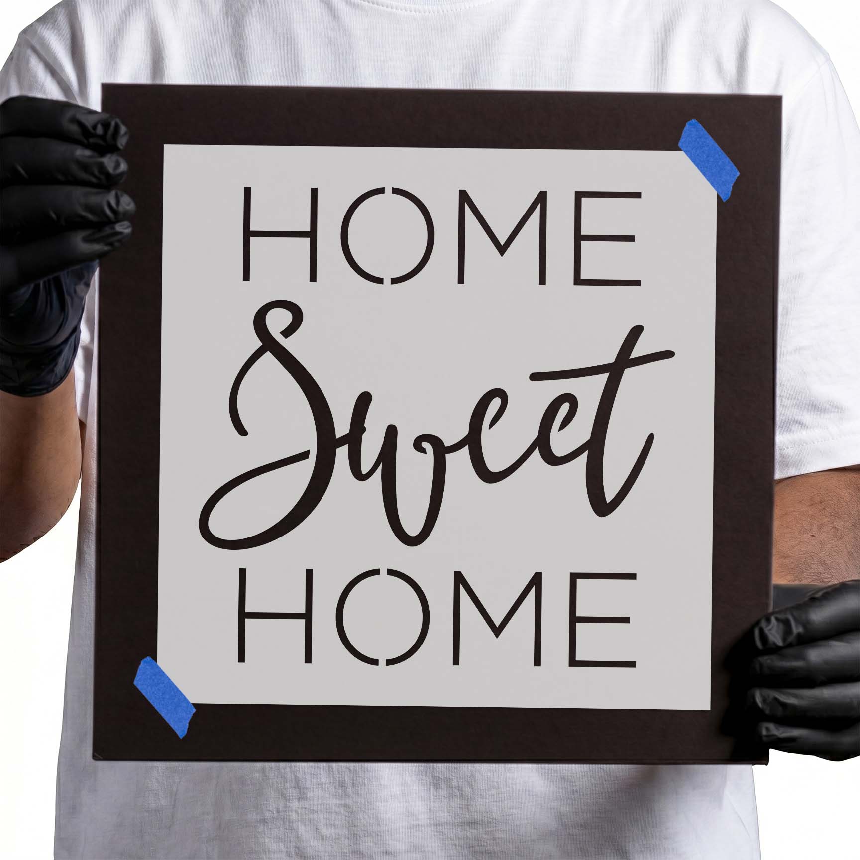 Person holding laser-cut Home Sweet Home Stencil