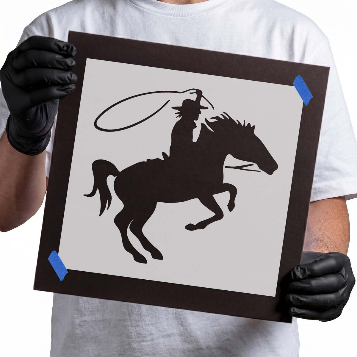 Cowboy stencil riding a galloping horse while swinging a lasso