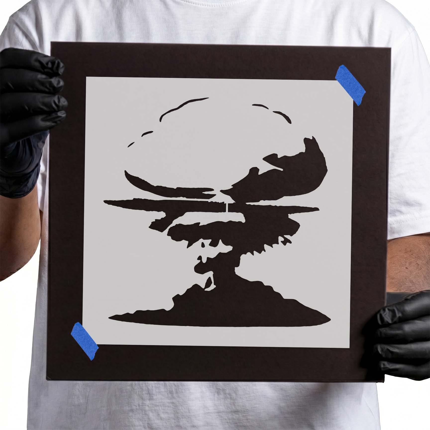 Person holding a laser-cut Mushroom Cloud Stencil