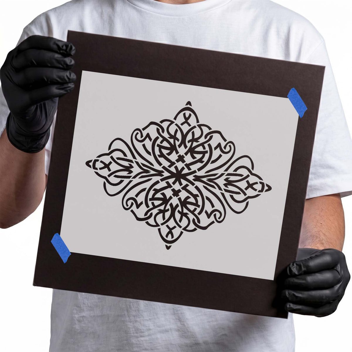 Ornate stencil featuring symmetrical interwoven scrollwork, looping flourishes, and pointed decorative accents