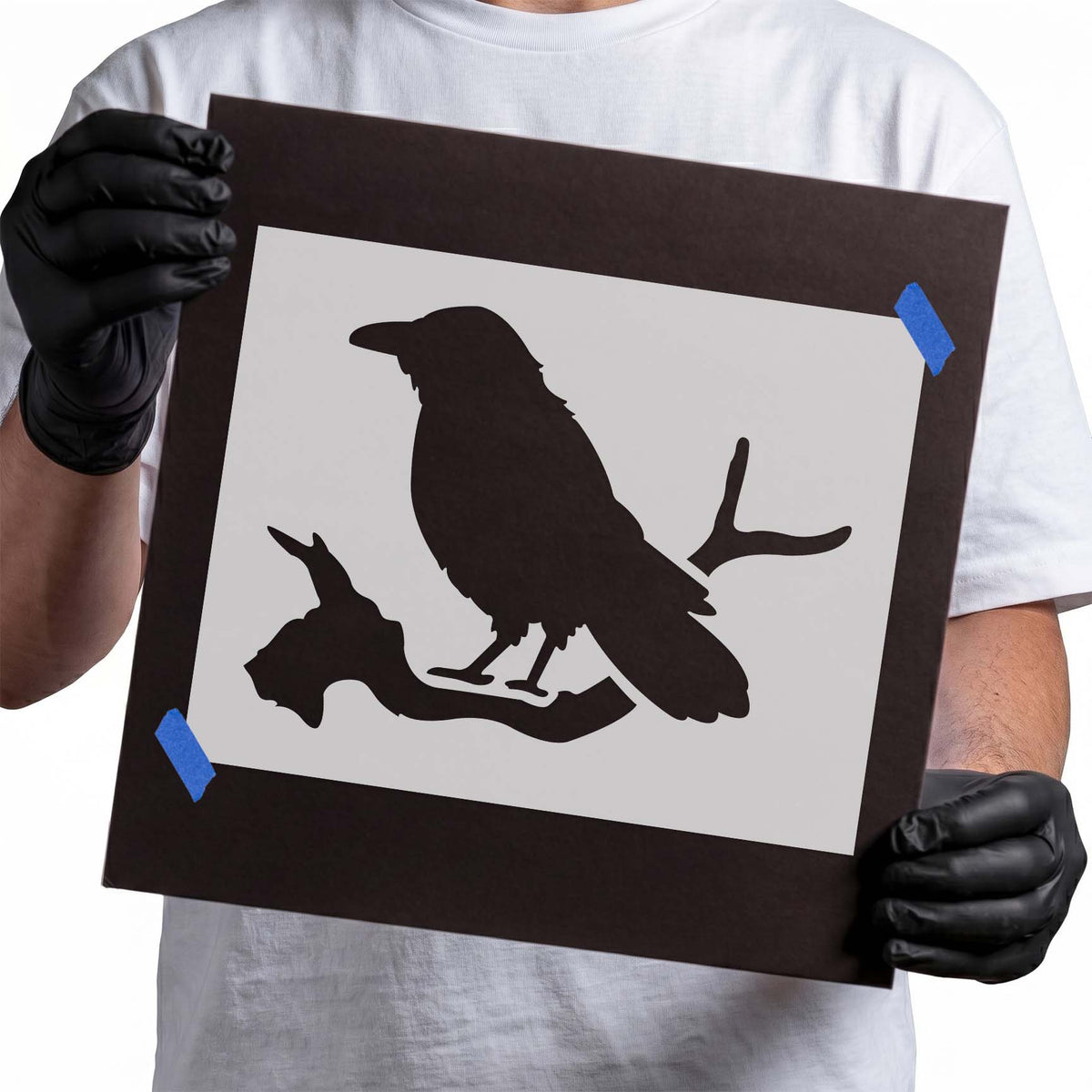 Perched crow stencil with detailed silhouette on bare branch