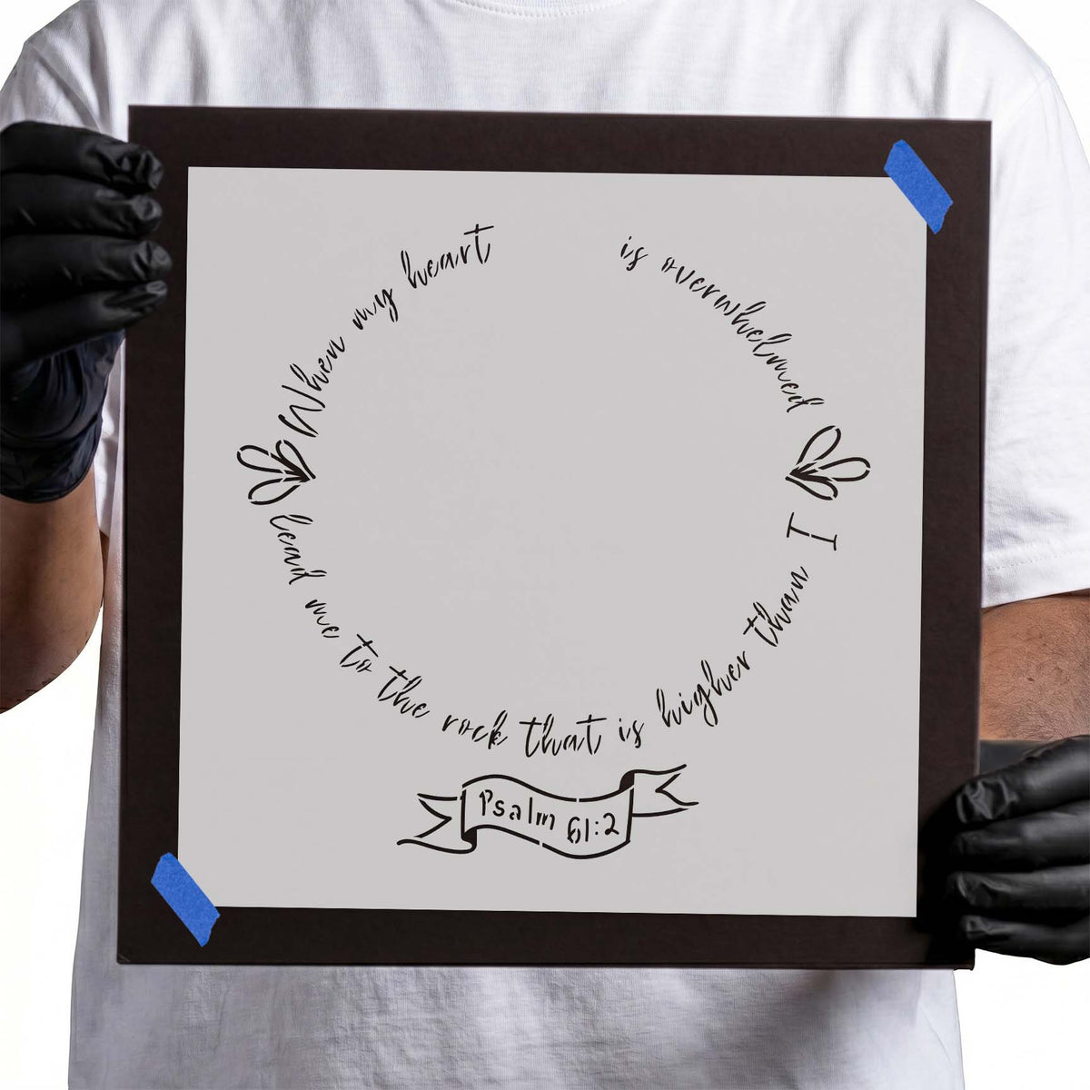 Psalm scripture stencil with circular handwritten lettering, floral flourishes, and Psalm 61:2 banner