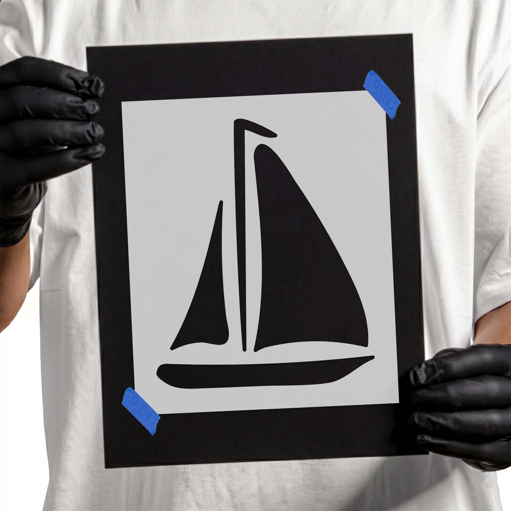 Gloved hands holding laser-cut Sailboat Stencil