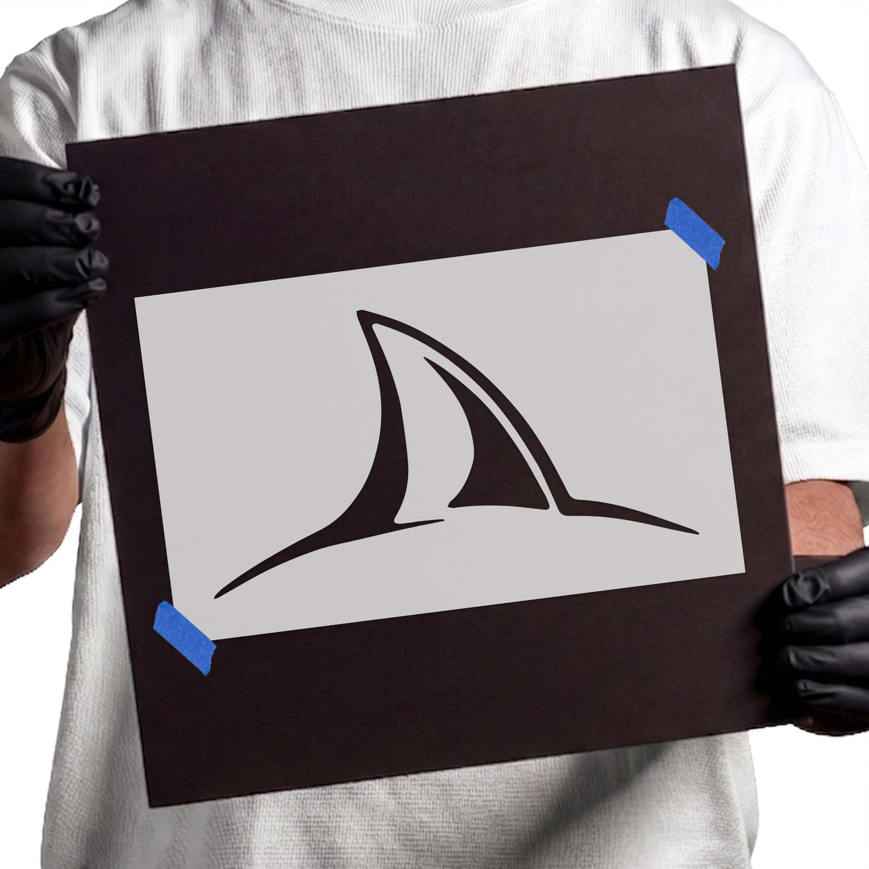 Shark fin stencil with curved dorsal fin above ocean waterline