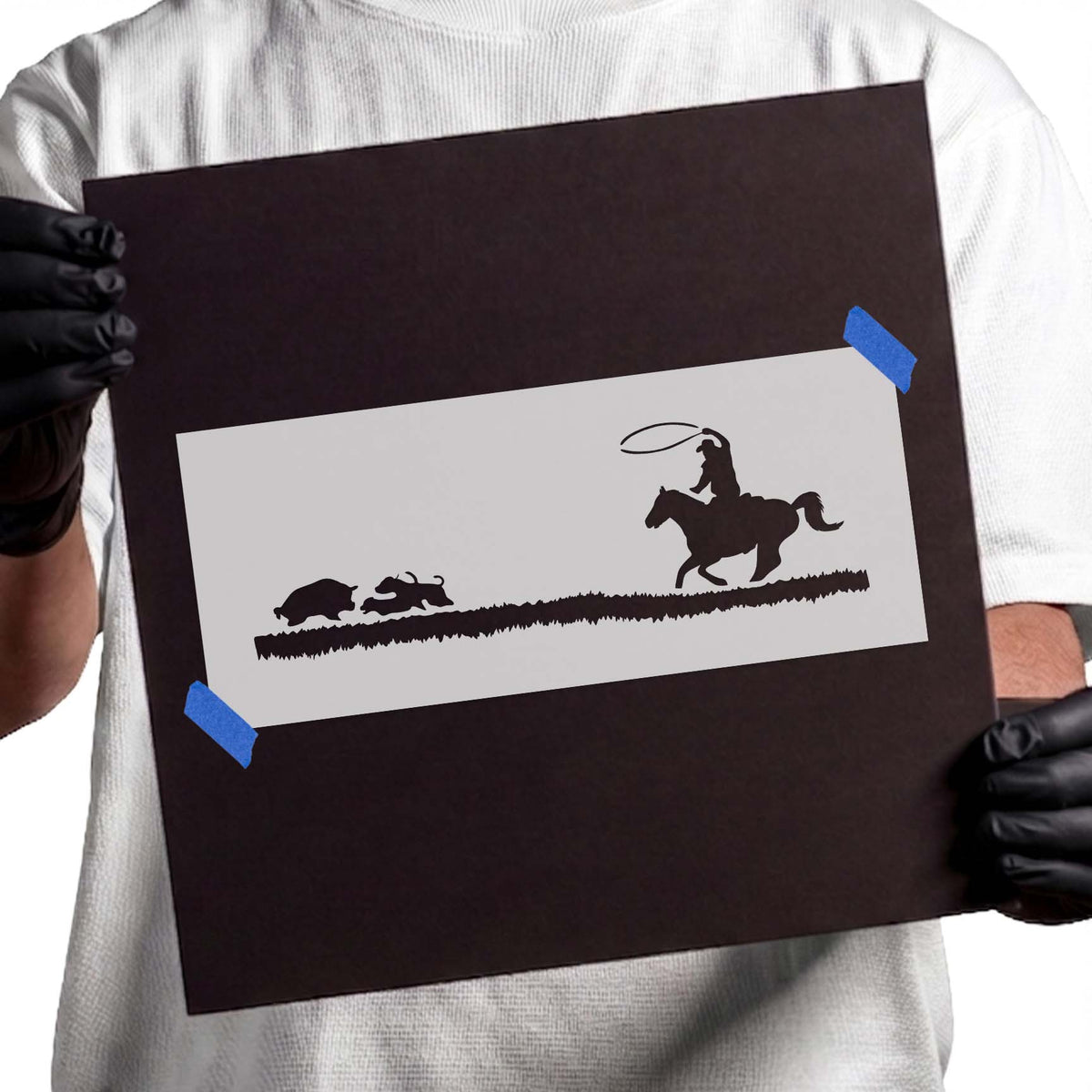 Cowboy stencil with horseback rider lassoing behind running cattle